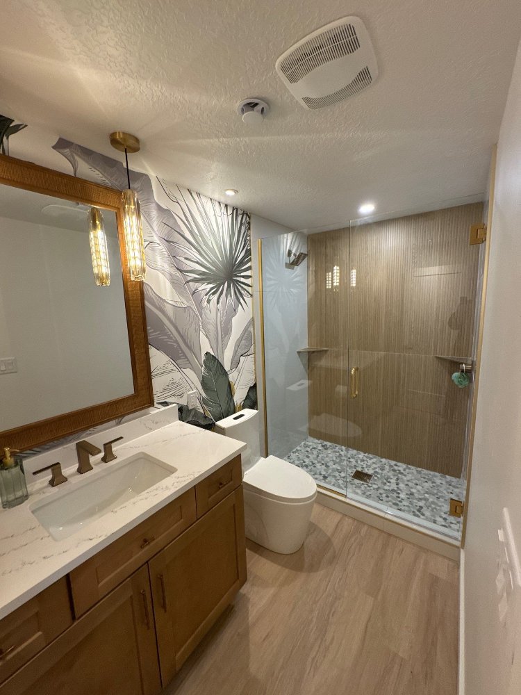 Basement bathroom with wood vanity, quartz countertop, and custom glass shower completed by RemodelCo in Daybreak, UT.-optimized