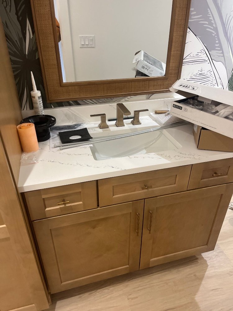 Custom bathroom vanity with quartz countertop being installed by RemodelCo during a basement finish in Daybreak, UT.-optimized