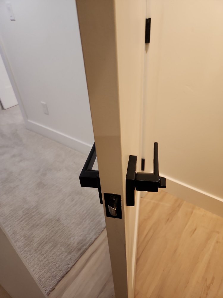 Matte black privacy door hardware installed on a white interior door by RemodelCo during a basement finish in Daybreak, UT.-optimized