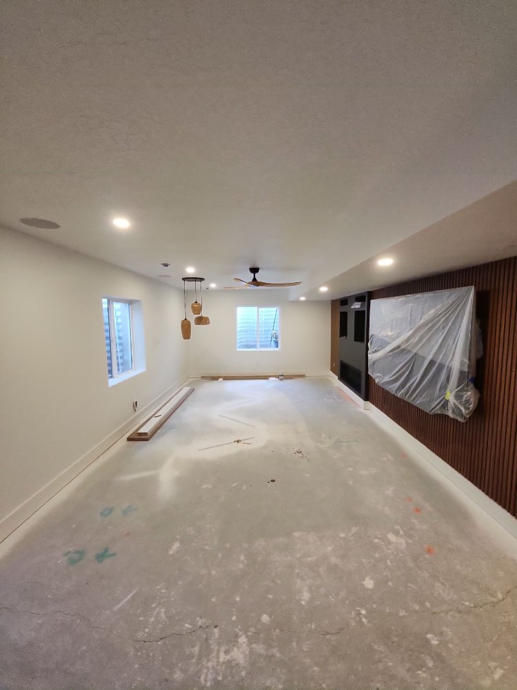 Spacious finished basement living area featuring a custom accent wall by RemodelCo in Daybreak, UT.-optimized