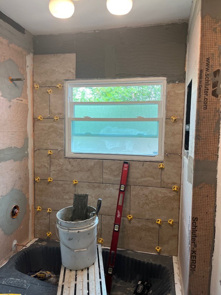 Bathroom renovation by RemodelCo in Salt Lake City, UT featuring custom tile work progressing on the tub surround wall.-optimized
