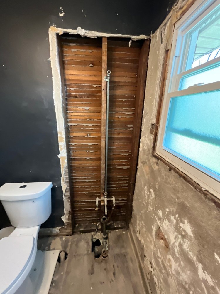 Bathroom renovation by RemodelCo in Salt Lake City, UT revealing wall framing and plumbing behind removed finishes.-optimized