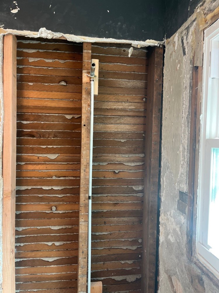 RemodelCo bathroom remodel in Salt Lake City, UT showing newly installed plumbing supply line within exposed wall framing.-optimized