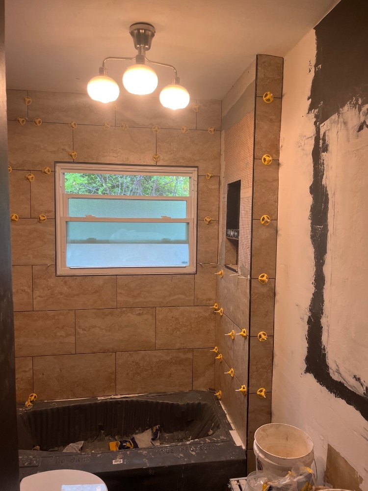 Salt Lake City bathroom remodeling project by RemodelCo showcasing advanced tile installation around the bathtub area.-optimized