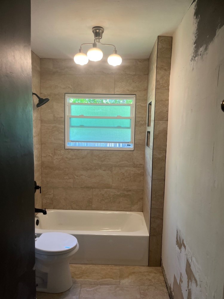 Updated bathroom renovation by RemodelCo in Salt Lake City, UT showcasing a custom tile tub surround and contemporary fixtures.-optimized