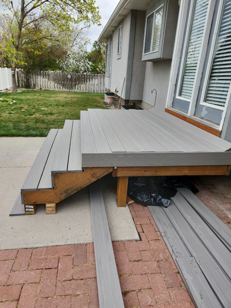 Composite deck boards being installed on a newly rebuilt backyard deck by RemodelCo in Midvale, UT.-optimized