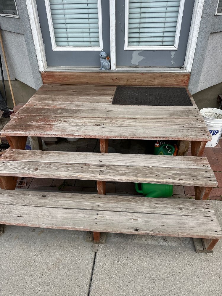 Front view of a weathered wood deck before reconstruction by RemodelCo in Midvale, UT.-optimized