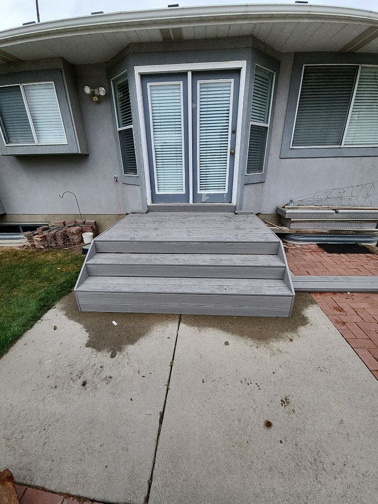 Front-facing view of a gray composite deck replacement project completed by RemodelCo in Midvale, UT.-optimized