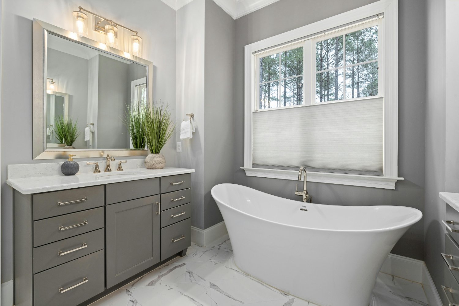 Contemporary bathroom with freestanding soaking tub, gray vanity, and marble flooring in a Sandy, UT bathroom remodel by Remodel-optimized