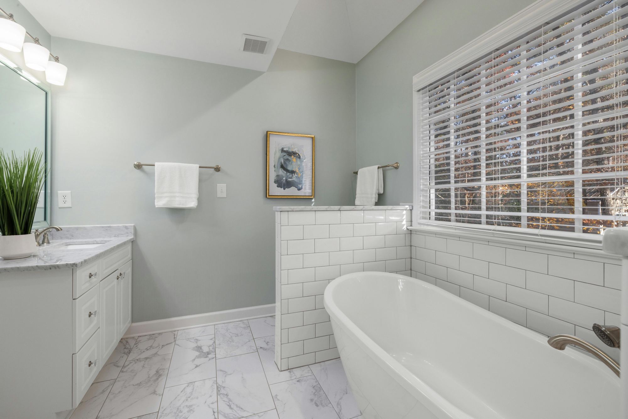 Updated bathroom with freestanding tub, subway tile accents, and marble-look flooring in a Sandy, UT bathroom remodel by Remodel-optimized