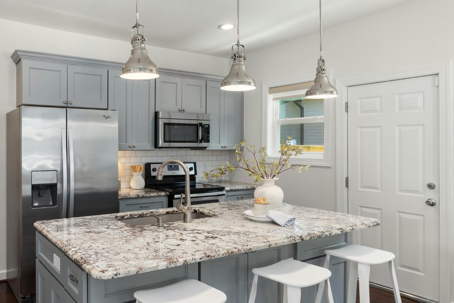 Transitional kitchen with granite island, gray cabinetry, and stainless steel appliances in a Sandy, UT kitchen remodel by Remod-optimized