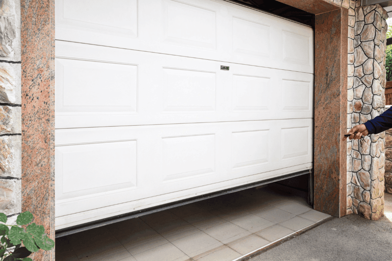 Image of a garage door being opened with a remote