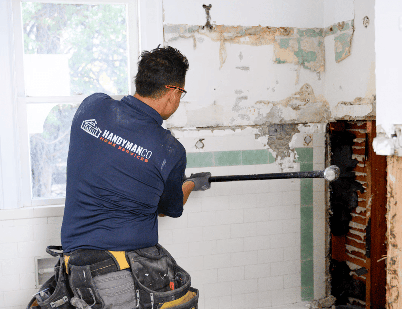 Image of an employee working on a demolishing using a sledgehammer