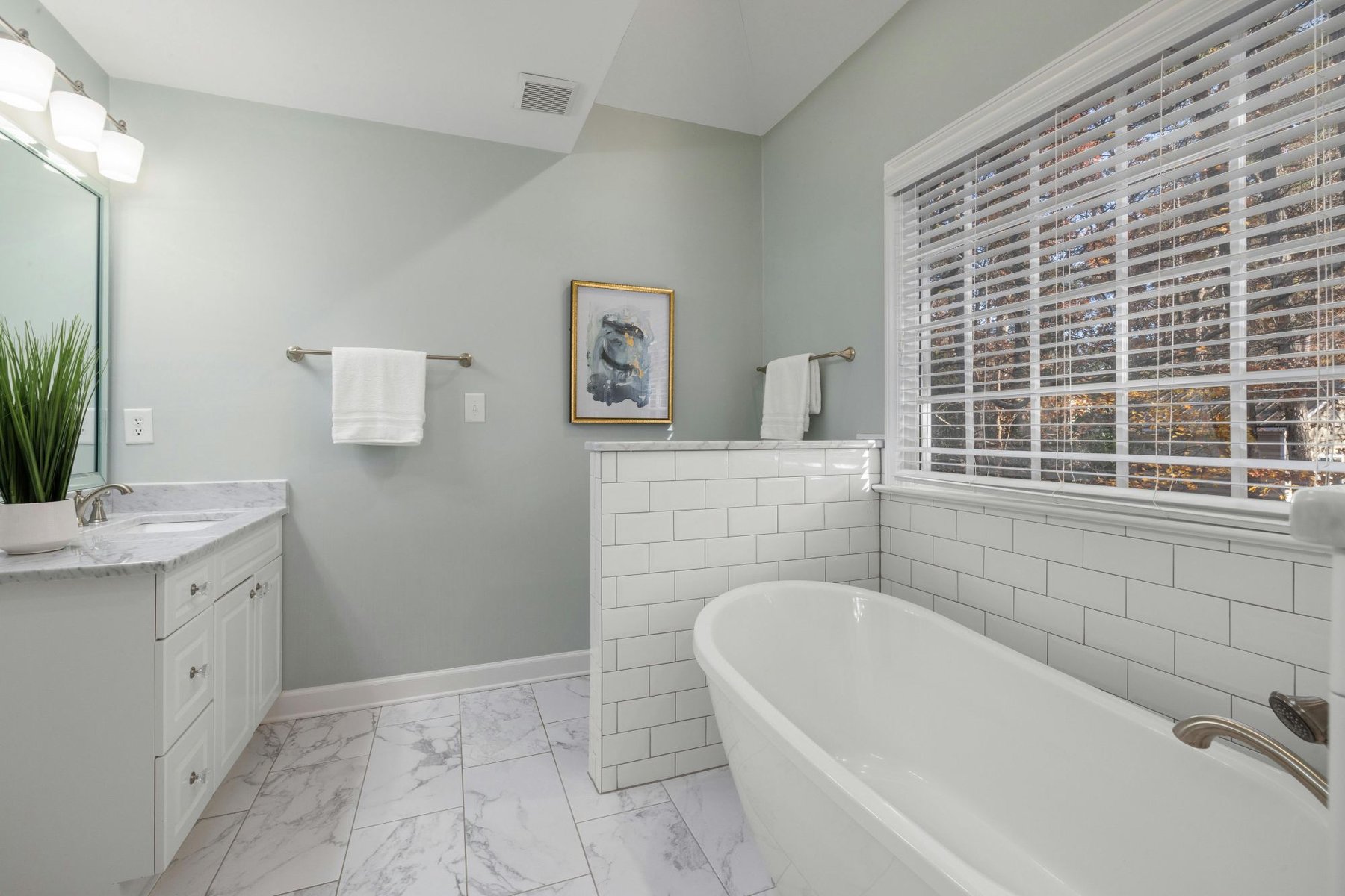 Updated bathroom with freestanding tub, subway tile accents, and marble-look flooring in a Sandy, UT bathroom remodel