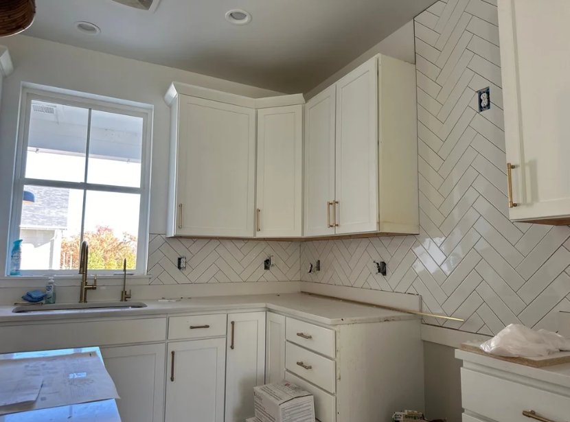 RemodelCo custom home kitchen in Sandy, UT featuring white shaker cabinets and herringbone tile backsplash installation-optimized