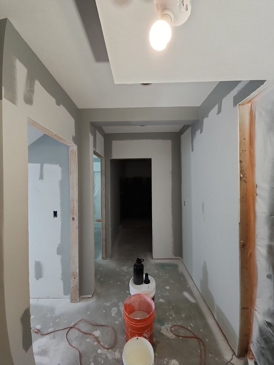 Basement hallway during drywall finishing and painting in a Herriman basement renovation.