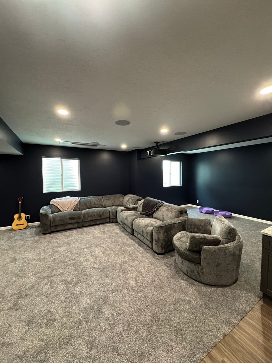 Spacious finished basement theater room with projector, seating, and recessed lighting.