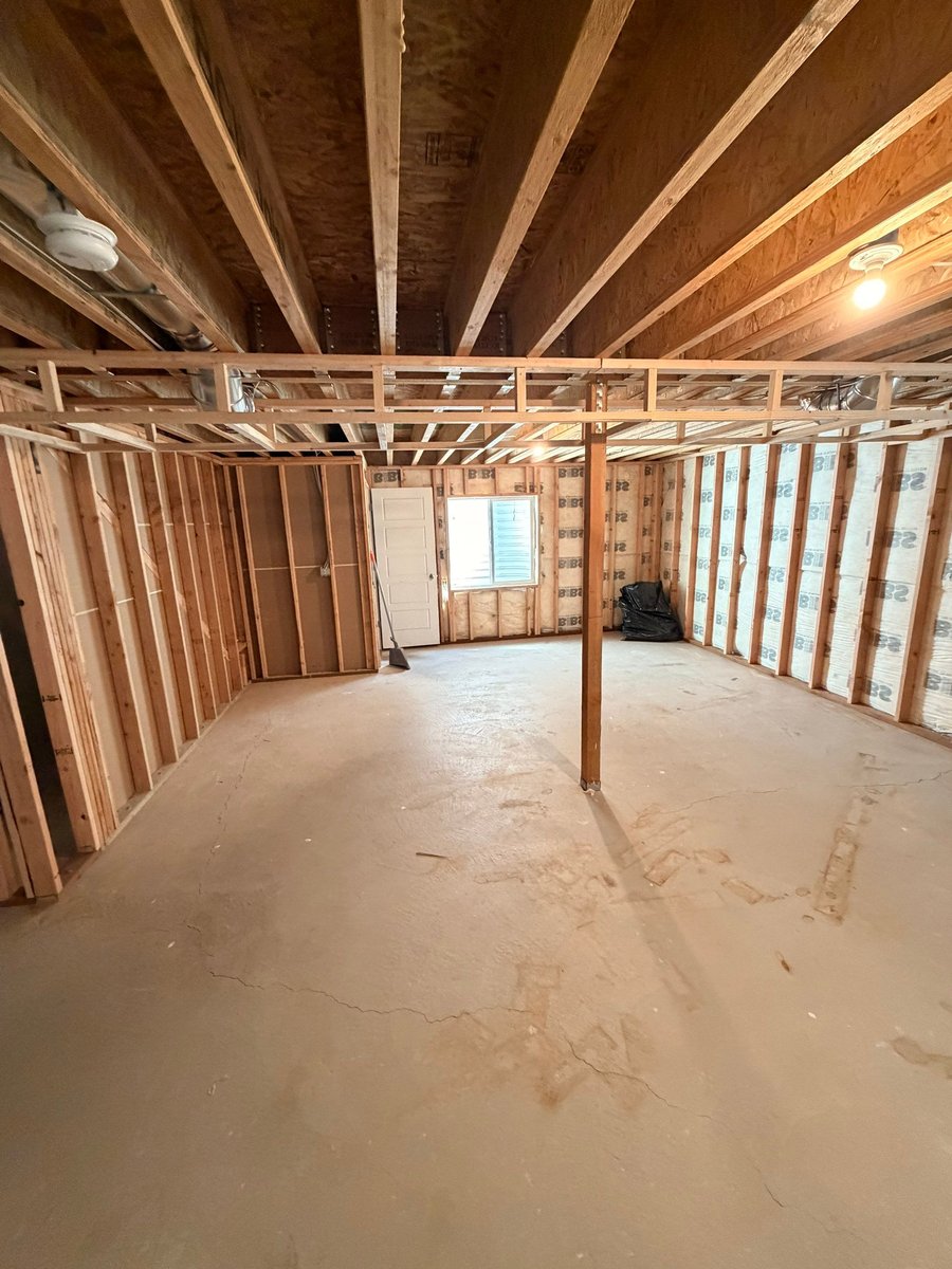 Basement finishing in progress with taped drywall, finished doors, and preparation for flooring and paint.