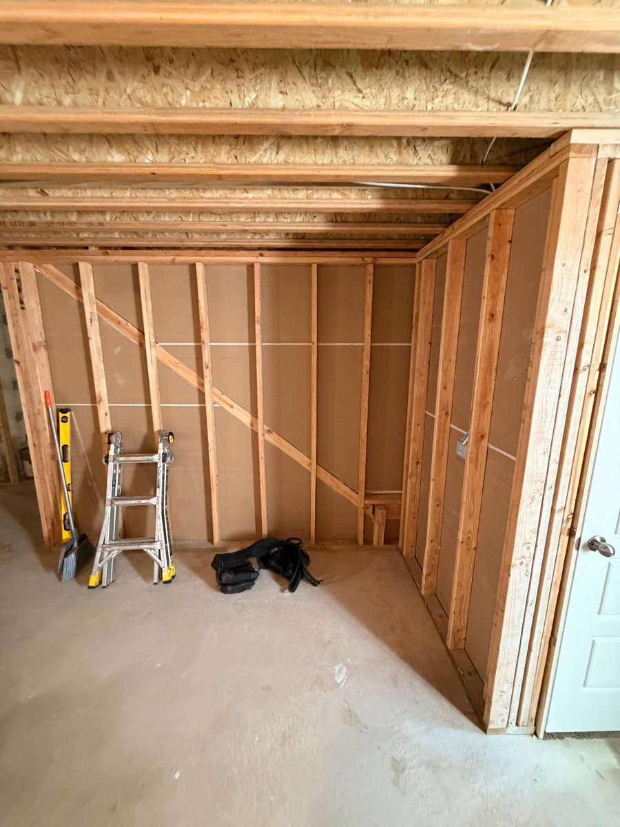Basement finishing in progress with taped drywall, finished doors, and preparation for flooring and paint.