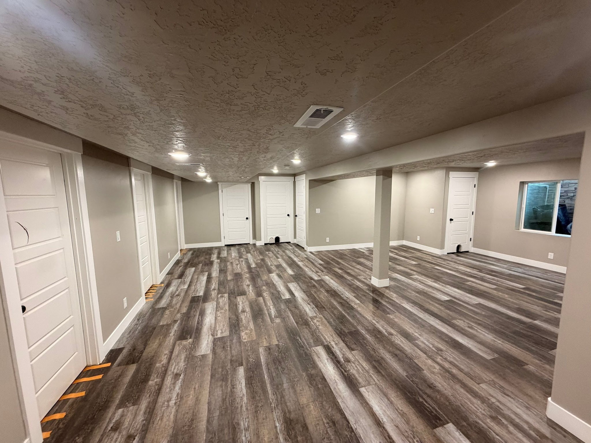 Finished basement floor plan with connected living spaces by RemodelCo in Herriman, Utah.